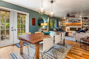 Dining space with light wood-type flooring, a wealth of natural light, french doors, and ceiling fan