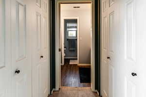 Hallway with dark hardwood / wood-style flooring