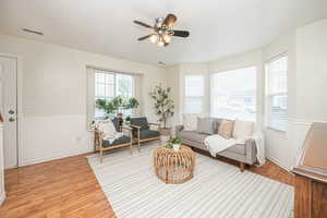 Living room with ceiling fan and light hardwood / wood-style flooring