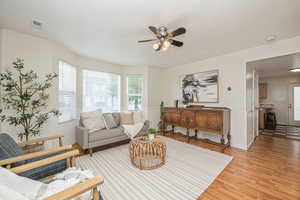 Living room with light hardwood / wood-style floors and ceiling fan