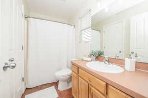 Bathroom featuring toilet, vanity, and tile patterned flooring