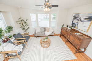 Living room with light wood-type flooring and ceiling fan