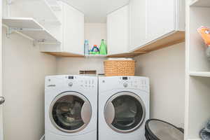 Laundry room featuring cabinets and washer and clothes dryer