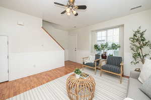 Sitting room with light wood-type flooring and ceiling fan