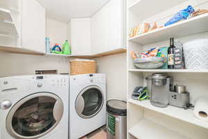 Washroom featuring cabinets and washer and dryer