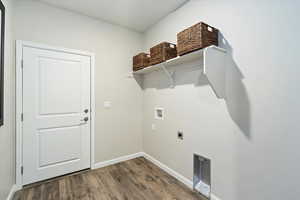 Clothes washing area featuring dark wood-type flooring, washer hookup, and electric dryer hookup