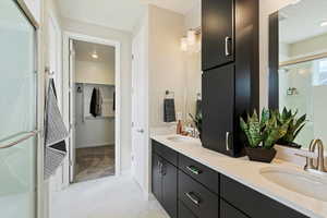 Bathroom featuring walk in shower and vanity