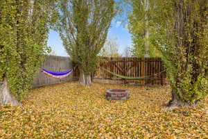 View of yard with an outdoor fire pit and trees for hammocks