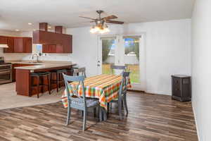 Dining area featuring dark wood-type flooring, ceiling fan, and french doors