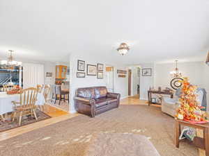 Living room featuring light wood-type flooring and an inviting chandelier