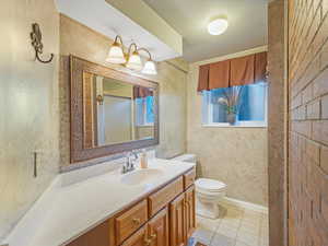 Bathroom featuring vanity, tile patterned floors, and toilet