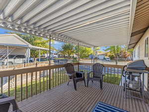 Wooden deck featuring a grill and a lawn