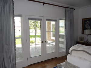 Bedroom with access to outside, dark hardwood / wood-style flooring, french doors, and ornamental molding