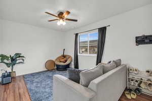 Living room with ceiling fan, hardwood / wood-style flooring, and a textured ceiling