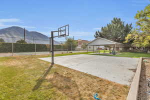 View of sport court featuring a lawn and a mountain view