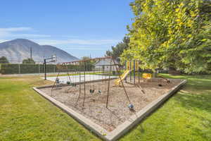 View of playground featuring a yard and a mountain view