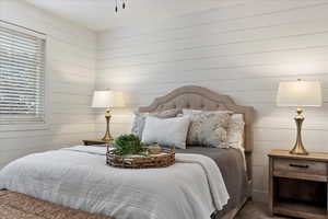 Bedroom featuring wooden walls