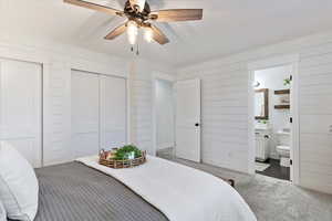 Bedroom featuring ornamental molding, dark colored carpet, ceiling fan, and ensuite bath