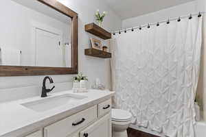 Full bathroom featuring toilet, shower / bath combo, vanity, and hardwood / wood-style flooring