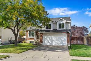 Tri-level home featuring a garage and a front yard