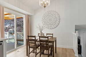 Dining area with light hardwood / wood-style floors and a notable chandelier