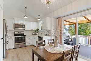 Kitchen featuring white cabinetry, a wealth of natural light, stainless steel appliances, and vaulted ceiling