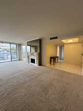 Unfurnished living room featuring light tile patterned floors and crown molding