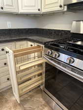 Kitchen with ventilation hood and stainless steel gas range