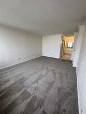 Carpeted empty room featuring crown molding