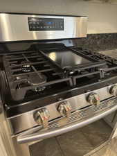 Interior details with tile patterned flooring and stainless steel gas stove