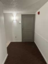 Entryway with a textured ceiling and light carpet