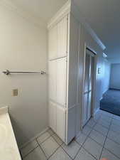 Primary Bathroom with vanity, tile  flooring, and ornamental molding