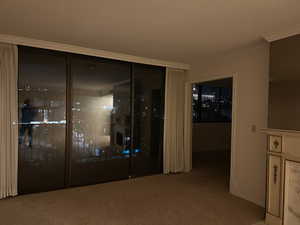 Interior space featuring ornamental molding and light carpet