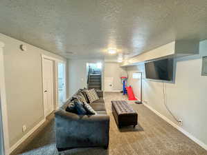 Carpeted living room featuring a textured ceiling