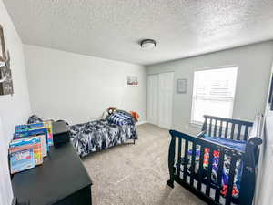 Carpeted bedroom featuring a textured ceiling