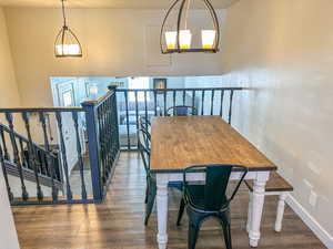 Dining area with wood-type flooring and a chandelier