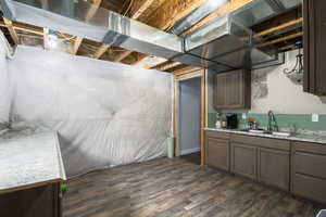 Basement featuring dark wood-type flooring and sink