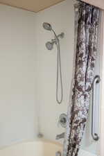 Bathroom with shower / bathtub combination with curtain