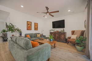 Living room with ceiling fan and light hardwood / wood-style floors