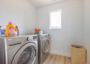 Laundry room featuring light wood-type flooring and independent washer and dryer