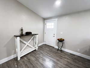 Entryway with lofted ceiling and dark hardwood / wood-style flooring