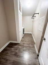 Clothes washing area with electric panel, dark hardwood / wood-style floors, and washer / dryer