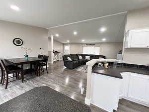 Kitchen featuring dark hardwood / wood-style floors, white cabinetry, and kitchen peninsula