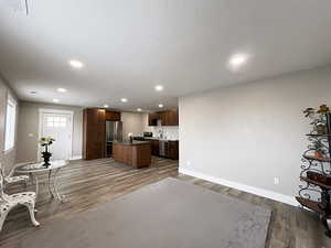 Kitchen featuring sink, appliances with stainless steel finishes, wood-type flooring, and a center island