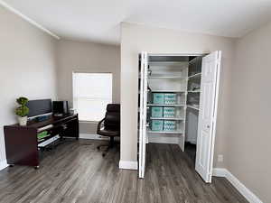 Office area featuring dark wood-type flooring and vaulted ceiling