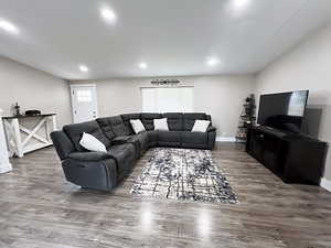 Living room with hardwood / wood-style flooring and vaulted ceiling