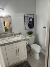 Bathroom 1 featuring toilet, vanity, and tile patterned floors