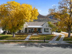 View of front facade featuring a front lawn, a mountain view, and a porch