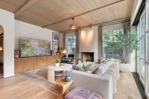 Living room featuring beam ceiling, light wood-type flooring, and wooden ceiling