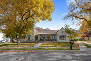 View of front of house with a mountain view, covered porch, and a front lawn